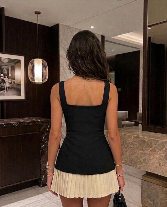 Back view of black mini dress with structured fit and pleated hem detail