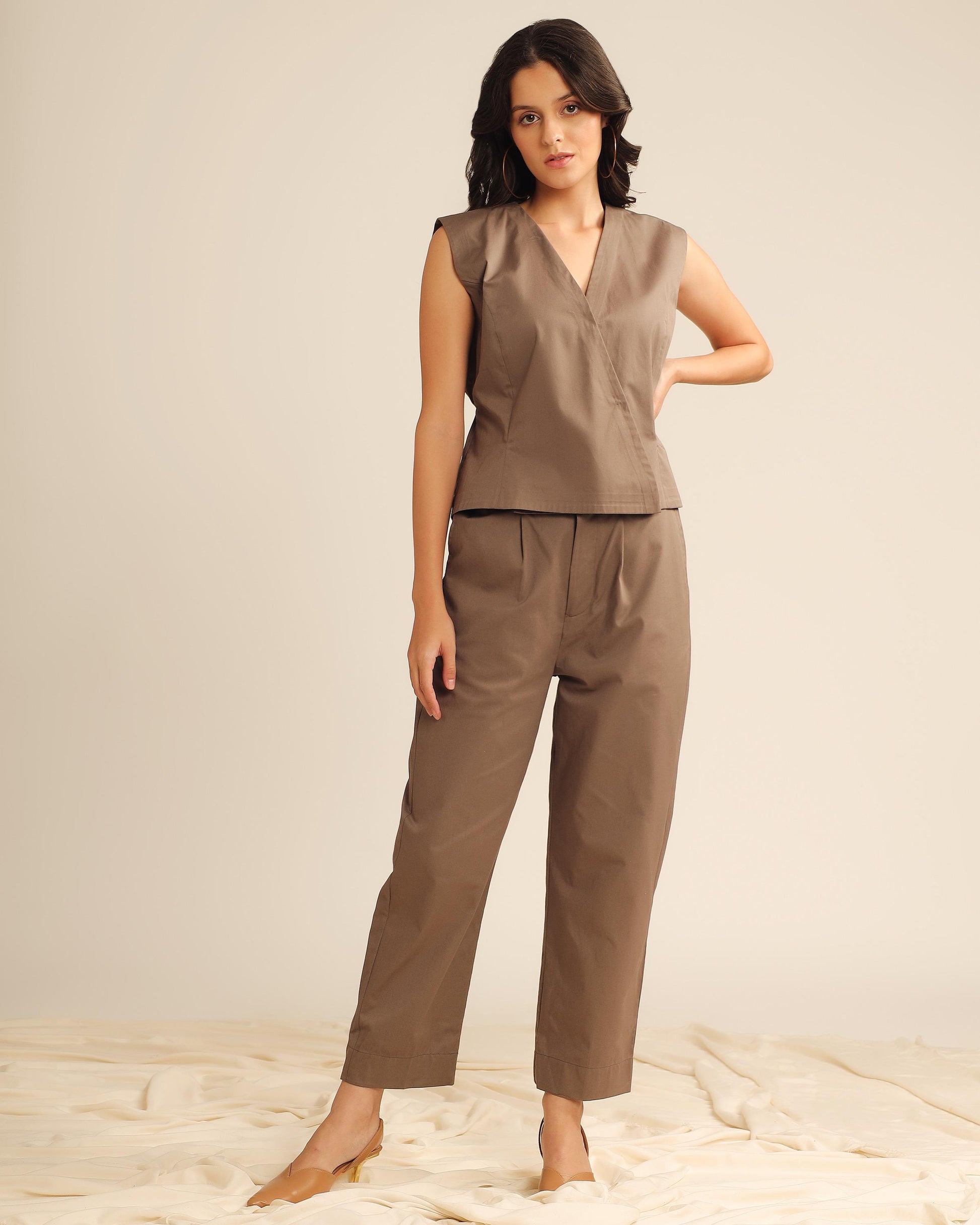 Woman wearing brown sleeveless wrap top and straight pants co-ord set, front view