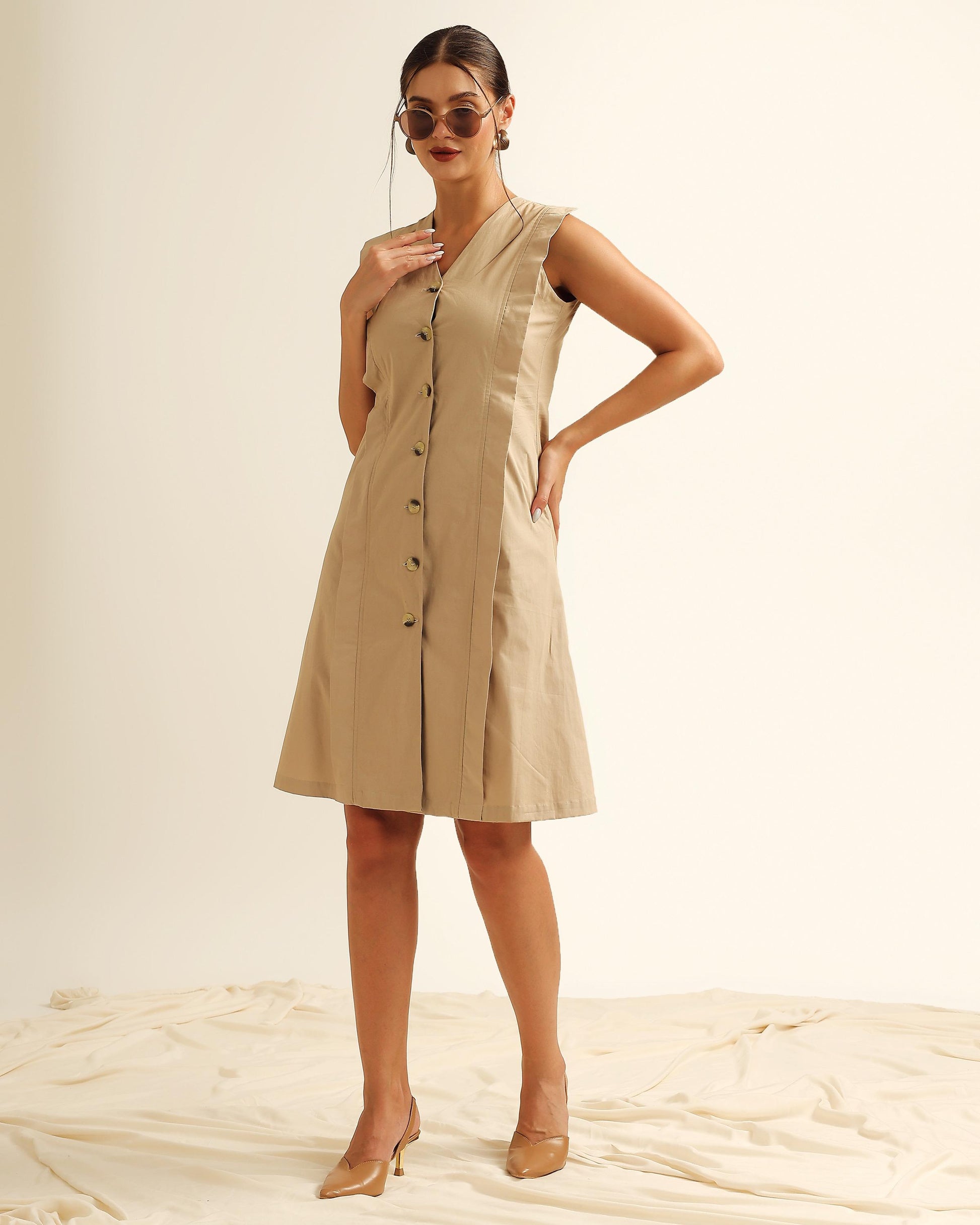 Woman wearing beige sleeveless button-down midi dress with panelled design front view