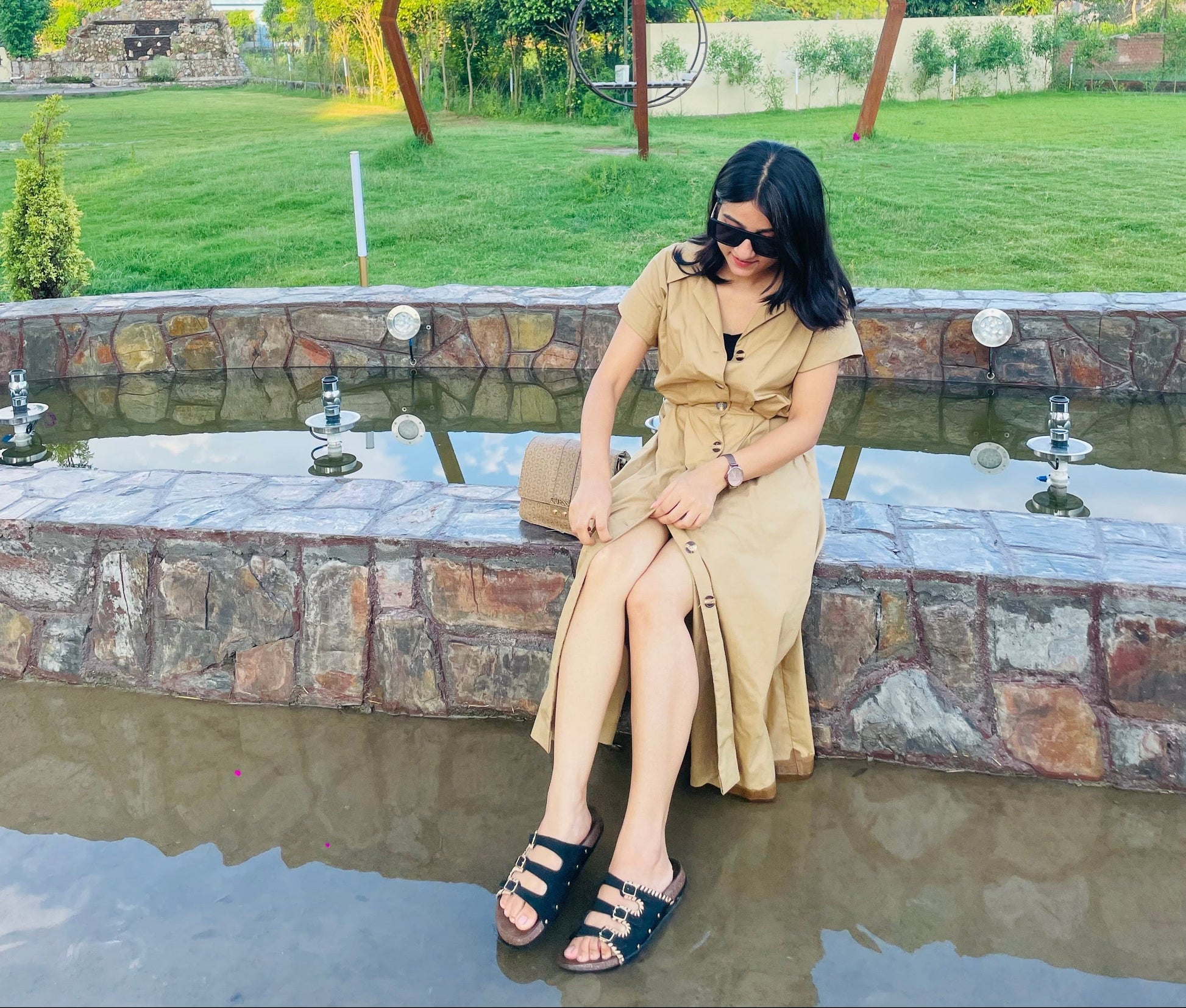 Woman wearing beige khaki midi dress with collared V neck and elastic waist full view outdoors