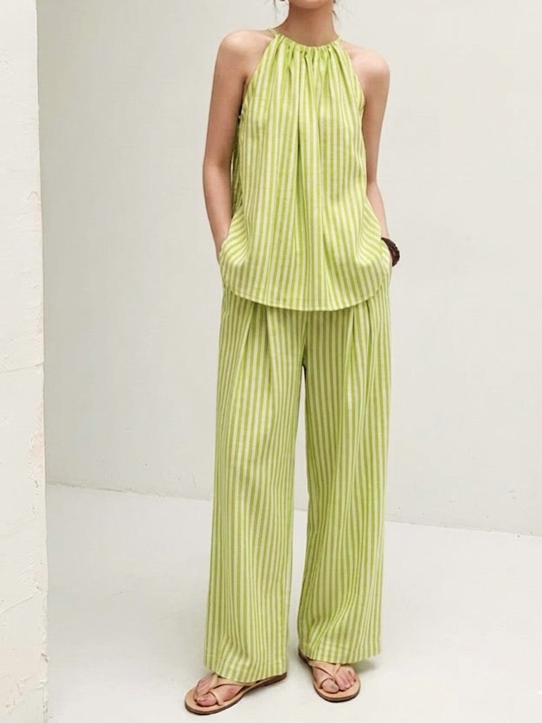 Front view of pistachio green striped halter co-ord set featuring a sleeveless gathered neckline top and flowy wide leg pants.
