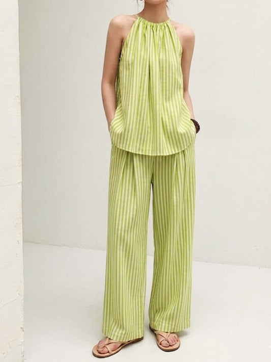 Front view of pistachio green striped halter co-ord set featuring a sleeveless gathered neckline top and flowy wide leg pants.
