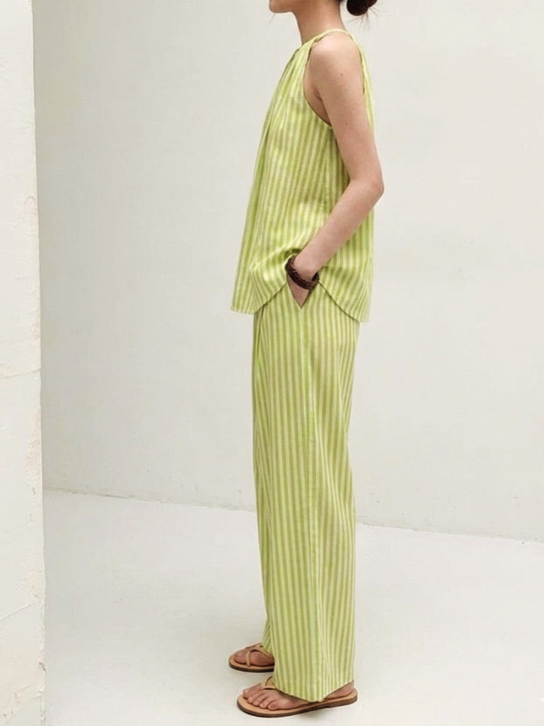 Side view of pistachio green striped matching set with halter neck sleeveless top and loose wide leg trousers.