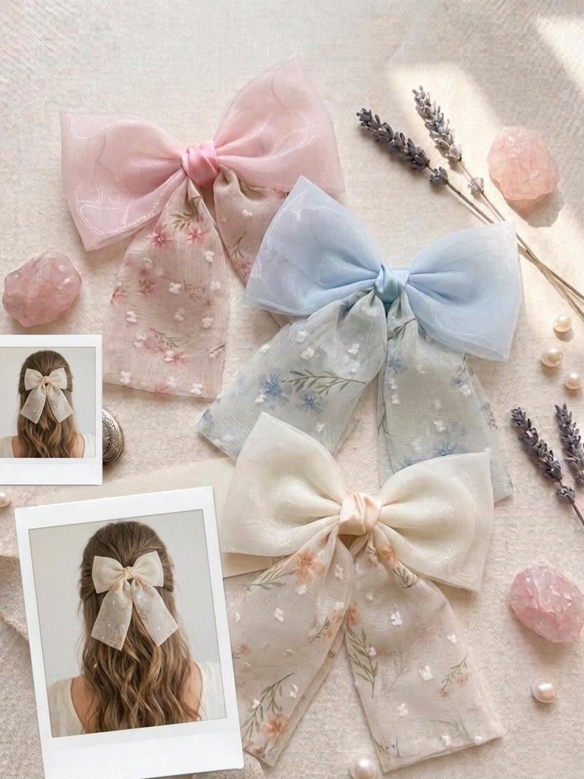 Pastel-colored hair bows on a textured surface with small decorative items.